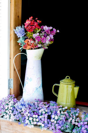 Beautiful flowers in white jug on wooden windowの写真素材