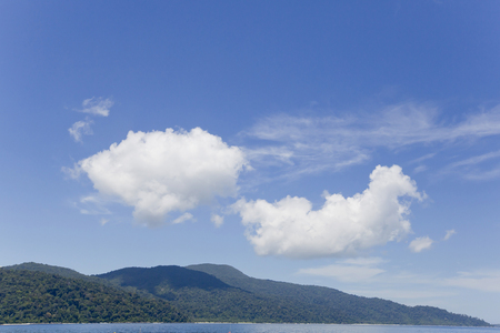 tropical island beach with sky and cloudsの写真素材