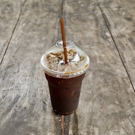Delicious ice coffee americano on old wood table.の写真素材