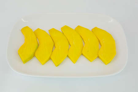 sliced pumpkin ready to be grilled isolate on white backgroundの写真素材