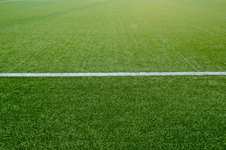 Straight white chalk line marking on grass background.