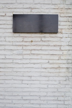 empty black sign made from marble board on white brick wallの写真素材