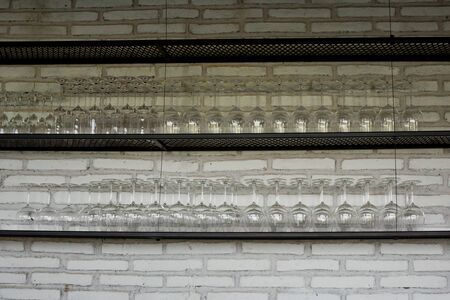 Empty glasses for wine above a bar rackの写真素材
