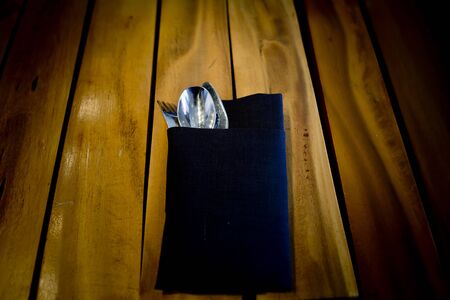 fork and spoon in dark blue clothon wooden table backgroundの写真素材