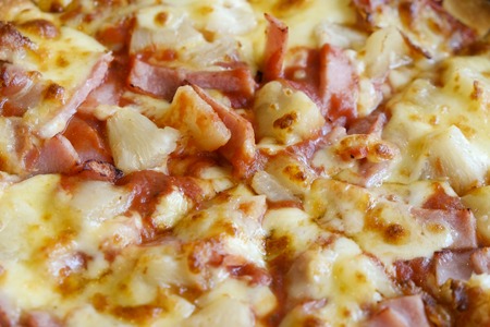 delicious hawaiian rustic style pizza made with fresh pineapples,ham and mozzarella cheeseの写真素材