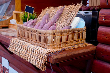 Sweet potato with wood skewer ready to roastedの写真素材