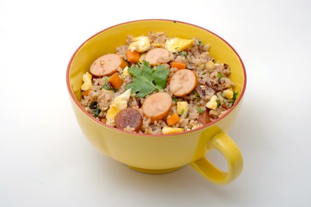 Fried rice with sausage and vegetables on white backgroundの写真素材