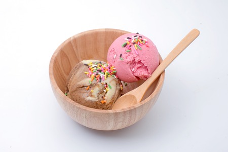 Multi-colored balls of delightful strawberry and coffee taste ice-cream in wooden bowl isolated