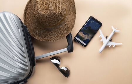 Flat lay  suitcase with brown hat, mini airplane, Thailand Passport, sunglasses and phone on pastelの写真素材