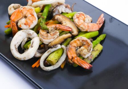 Stir fried asparagus with squid and shrimp with oyster sauce.の写真素材