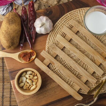 Wooden heating pad with a glass of milk, spoon and forkの写真素材