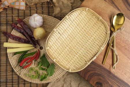 Wood tray with Thai herbs and spoon and fork with free space forの写真素材