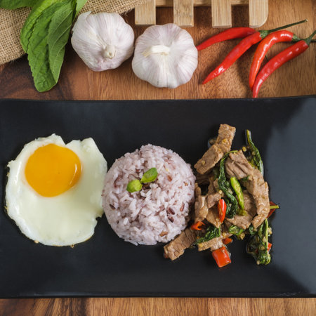 Stir-fried beef basil with fried egg and riceberry rice.の写真素材