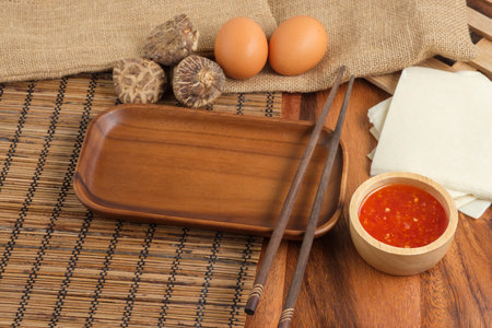 Empty plates with chopsticks by wooden styles. Space for text. Tの写真素材