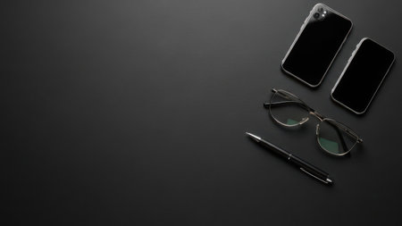 Flat lay of modern black technology gadgets and accessories on dark surfaceの素材