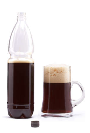 Beer is poured into a mug from a flaskの写真素材