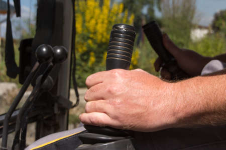 Operating the shift lever of an excavatorの写真素材