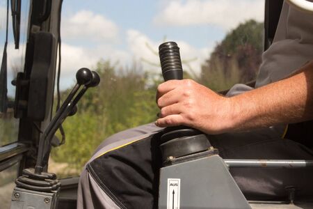 Operating the shift lever of an excavatorの写真素材