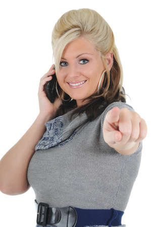 A attractive young blonde woman using her smart phone, and pointing at the camera. Isolated on a solid white background. の写真素材