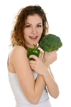 Young smiling woman holding broccoli and green peper, isolated on white backgroundの写真素材