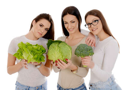 Beautiful three women hodlng savoy, lettuce and broccoli isoalted on white backragaundの写真素材