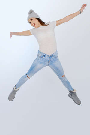 Beoutiful young girl jumping, over blue background, isoaltedの写真素材