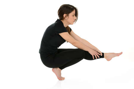 Young woman doing yoga asana Eka pada malasana, one legged garland pose  isolated on white backgroundの写真素材