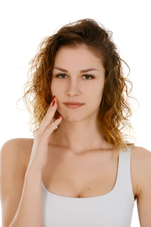 Beautiful woman face close up studio on white hand touching skinの写真素材