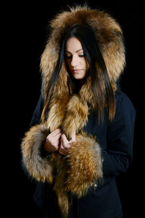 Fashion Model Girl Portrait wearing fur coat isolated on black backgroundの写真素材