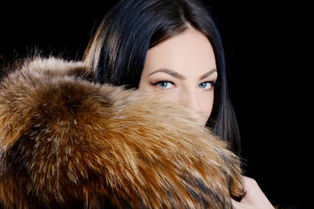 Fashion Model Girl Portrait wearing fur coat isolated on black background