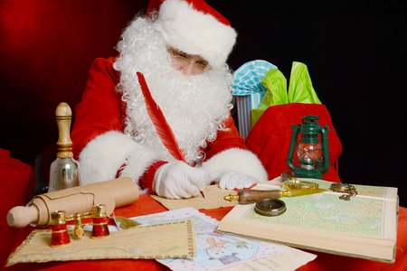 Portrait of Santa Claus answering Christmas letters. Santa Claus at his office, writing letterの写真素材
