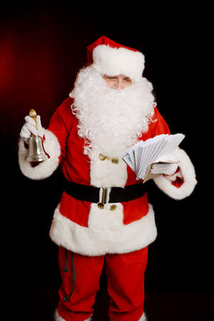 Santa Claus holding hand bell and children's letters. Traditional Santa Claus isolatedの写真素材