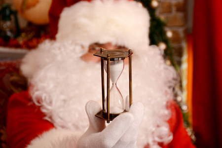 Santa Claus at his home holding hourglass. Selected focusの写真素材