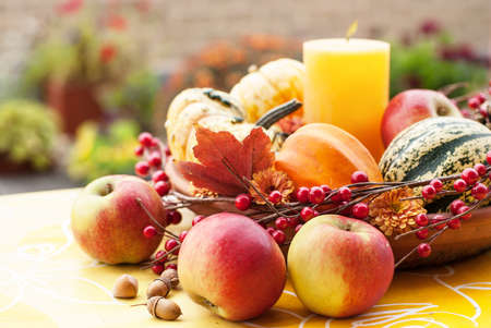 Thanksgiving decor in a autumn garden with pumpkins, candle and applesの写真素材