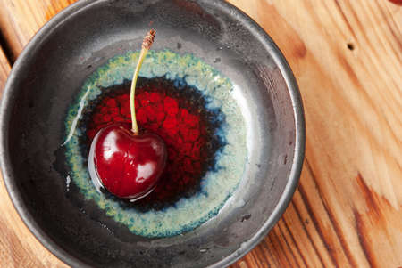 Sweet fresh cherry in a ceramic bowlの写真素材