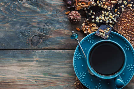 Assortiment of chocolate and cup of coffee on wooden tableの写真素材