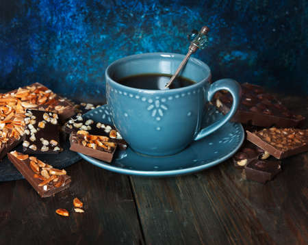 Cup of coffee, assortment of  chocolates on wooden tableの写真素材