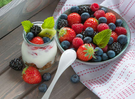 Healthy breakfast, muesli with fresh blueberry, blackberry, raspberries, strawberry, kiwi, mint and yogurtの写真素材