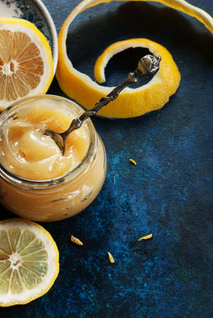 Homemade lemon curd in glass jar, with fresh lemonsの写真素材