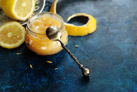 Homemade lemon curd in glass jar, with fresh lemonsの写真素材