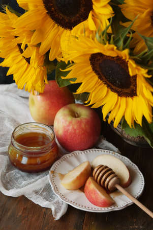 Sunflowers, apple and honey on a wodden tableの写真素材