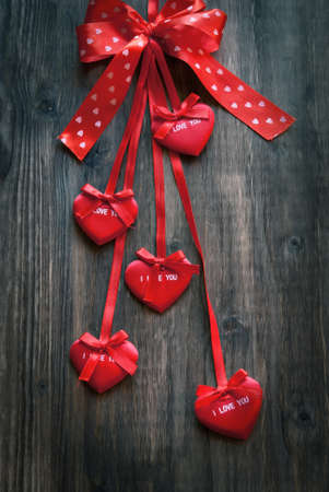 Valentine card with red bow and hearts on a wooden background, valentine day backgroundの写真素材