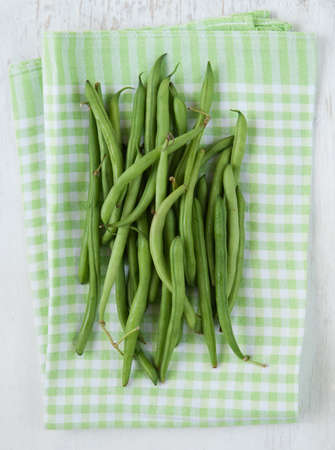 Bunch of fresh picked green beans on a wooden white rustic table