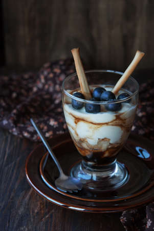 Cheese dessert in glass with berries, chocolate and breadsticksの写真素材