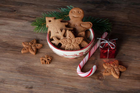 Gingerbread and christmas cookies in a bowl on wooden background with a place for text