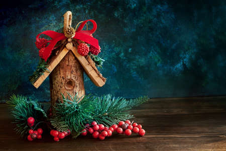 Sweet home. Christmas decor with wooden bird house on dark background. Selective focusの写真素材