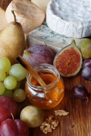 Variation of cheese with fruits and honey on rustic backgroundの写真素材