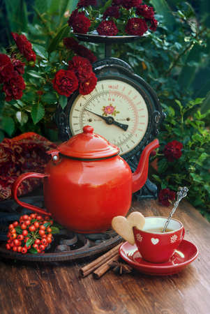 Beautiful flowers and cup of tea with cookies at wooden table, autumn decor, Selective focusの写真素材