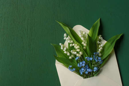 Mother's day card with envelope and forget-me-not flowers and lilies of the valleyの写真素材