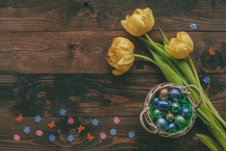 Easter background with flowers. Easter eggs with easter decor on the wooden tableの写真素材